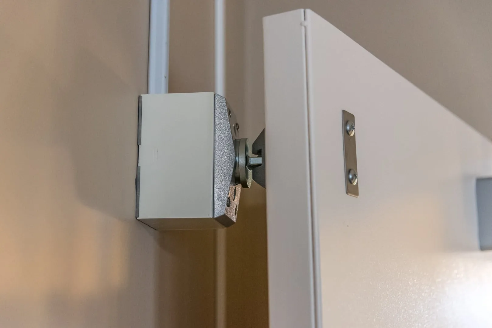Magnetic fire-door hold-open device installed beside a corridor door